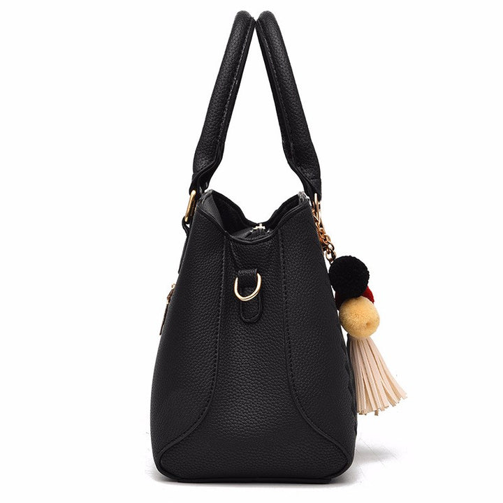 Henkeltasche mit Flechtprägung und Pompon-Anhänger
