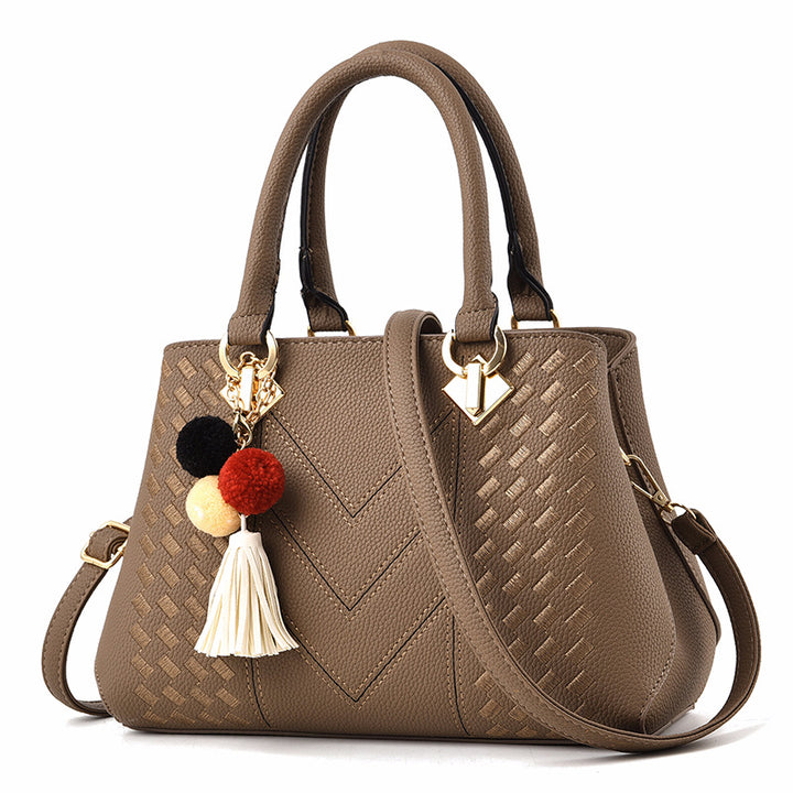 Henkeltasche mit Flechtprägung und Pompon-Anhänger