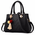 Henkeltasche mit Flechtprägung und Pompon-Anhänger