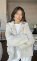 Frau in kurzer wollweisser Teddyjacke