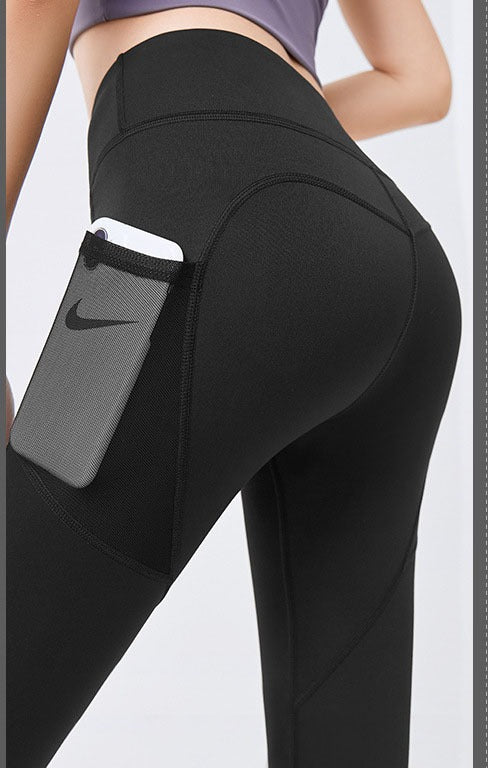 Frau in High-Waist Leggings mit Handytasche