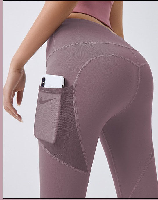 Frau in High-Waist Leggings mit Handytasche