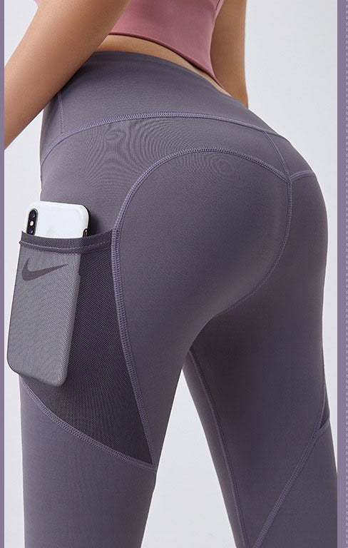 Frau in High-Waist Leggings mit Handytasche