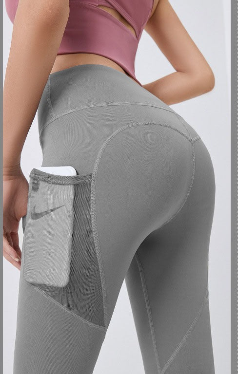 Frau in High-Waist Leggings mit Handytasche