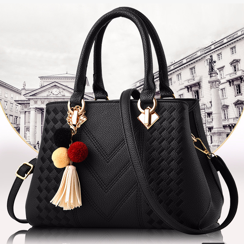Henkeltasche mit Flechtprägung und Pompon-Anhänger